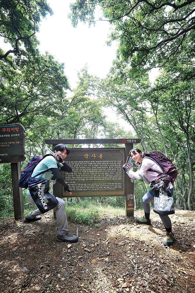 BAC인증지점인 국사봉 정상의 안내판. 정상 일대의 쓰레기 정화 활동을 한 두 사람이 장난스런 포즈를 취했다.