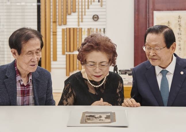 안중근 의사의 가족사진첩을 보고 있는 유족 안기영 여사(가운데), 안기영 여사 부군 윤종구(왼쪽), 유영렬 안중근의사기념관 관장(오른쪽). 삼성문화재단 제공