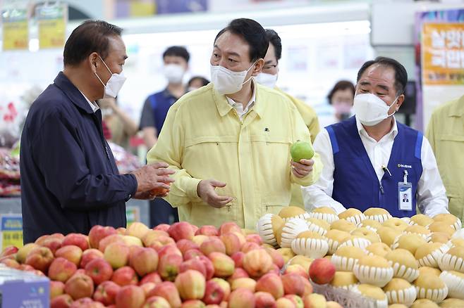 물가 점검에 나선 윤석열 대통령이 11일 서울 서초구 하나로마트 양재점 과일 코너에서 관계자들과 대화를 나누고 있다. /대통령실 제공
