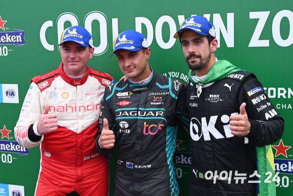 13일 서울 송파구 잠실올림픽주경기장 일대에서 열린 '2022 하나은행 서울 E-프리(E-Prix)' 15라운드 본선에서 우승을 차지한 재규어 TCS 레이싱 팀 소속 미치 에반스(뉴질랜드, 가운데)가 준우승을 차지한 마힌드라 레이싱 팀 소속 올리버 롤랜드(영국, 왼쪽), 로킷 벤추리 레이싱 팀 소속 루카스 디 그라시(브라질)와 기념촬영을 하고 있다. [사진=김성진 기자]