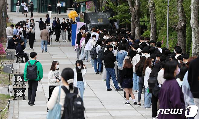 서울 성북구 정릉로 국민대학교 성곡도서관 앞에서 진행된 '총장님이 쏜다! 중간고사? 오히려 좋아' 이벤트에서 재학생들이 커피를 받기 위해 줄을 서 있다. . 2022.4.21/뉴스1 ⓒ News1 김진환 기자