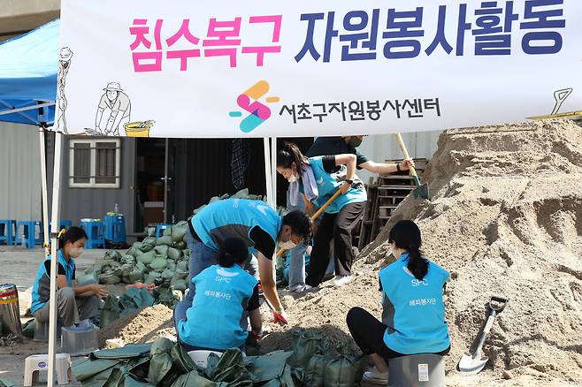 SPC그룹 임직원들이 지난 12일(금) 서울 서초구 반포종합운동장에서 하천 범람 방지를 위한 모래주머니를 제작하고 있다.(SPC그룹 제공)