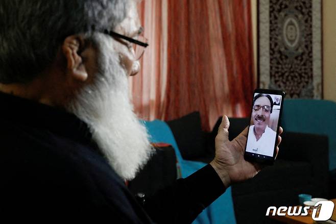 알리 하반 바카이가 파키스탄 카라치에 있는 자택에서 인도 국민인 아비드 하산 바카이와 영상 통화를 하고 있다. ⓒ 로이터=뉴스1