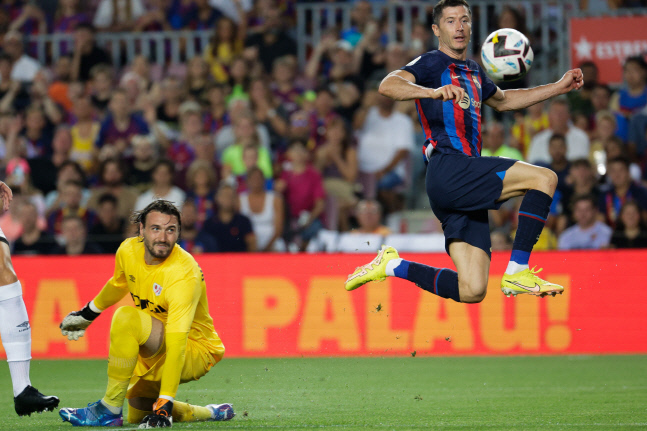 FC바르셀로나의 로베르트 레반도프스키(오른쪽)가 13일(현지시간) 홈에서 열린 라요 바예카노와의 2022~2023 스페인 라리가 1라운드에서 상대 골키퍼를 제치고 공을 다루고 있다. 바르셀로나|EPA 연합뉴스