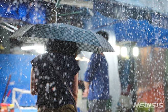 [서울=뉴시스] 권창회 기자 = 비가 내리고 있는 8일 오후 서울 강동구 둔촌역 전통시장에서 시민들이 우산을 쓰고 이동하고 있다. 2022.08.08. kch0523@newsis.com
