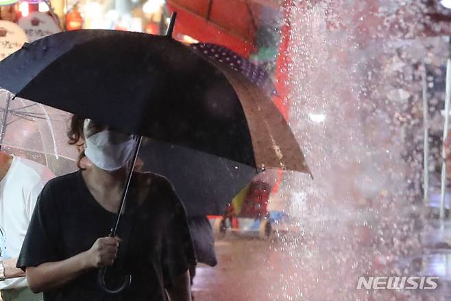 [서울=뉴시스] 권창회 기자 = 비가 내리고 있는 지난 8일 오후 서울 강동구 둔촌역 전통시장에서 시민들이 우산을 쓰고 이동하고 있다. 2022.08.08. kch0523@newsis.com