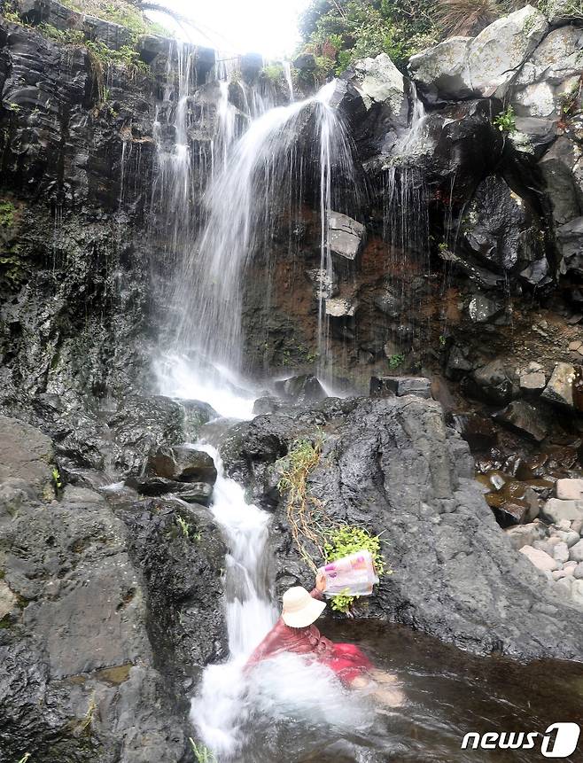 절기상 말복인 15일 제주 서귀포시 정방동 '소(小)정방폭포'에서 피서객들이 폭포수를 맞으며 더위를 쫓고 있다.2022.8.15/뉴스1 ⓒ News1 고동명 기자