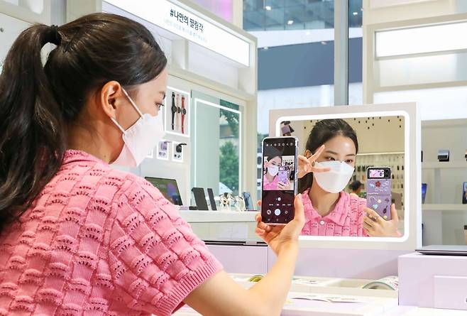 삼성전자는 ‘갤럭시 Z폴드 4'와 '갤럭시 Z플립 4’ 사전 판매를 16일부터 22일까지 7일간 진행한다고 15일 밝혔다. 사진은 갤럭시 스튜디오 삼성 디지털프라자 홍대본점에서 방문객이 갤럭시 Z플립4로 거울 셀카를 촬영하하는 모습. /삼성전자 제공