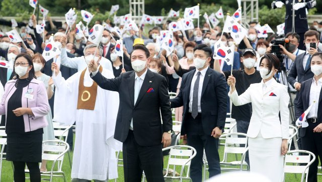 윤석열 대통령과 부인 김건희 여사가 15일 서울 용산 대통령실 잔디마당에서 열린 제77주년 광복절 경축식에서 참석자들과 함께 만세 삼창을 한 뒤 태극기를 흔들고 있다. 2022.08.15. 뉴시스