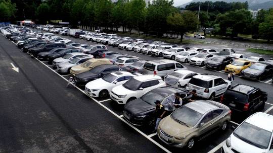 지난 11일 오후 경기도 과천 서울대공원 주차장에 마련된 DB손해보험, 현대해상 임시 보상서비스센터에 연일 내린 집중호우에 침수 피해를 입은 차량들이 주차되어 있다. 연합뉴스