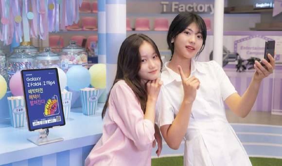 홍대 T팩토리 매장에서 SK텔레콤 홍보모델이 갤럭시Z폴드4·플립4 구매 혜택을 소개하고 있는 모습. [사진=SK텔레콤]
