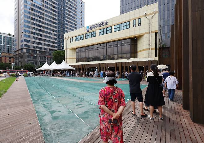 광복절인 15일 오전 서울 송파구보건소에 마련된 코로나19 임시선별진료소를 찾은 시민들이 검사를 기다리고 있다. [사진 출처 = 연합뉴스]