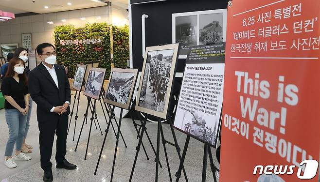 대전 동구가 16일부터 31일까지 구청 로비에서 6‧25전쟁 특별 사진전 ‘This is War!(이것이 전쟁이다!)’를 개최하는 가운데 박희조 구청장이 전시된 작품을 둘러보고 있다. (대전 동구 제공)