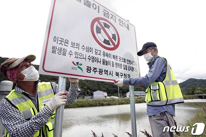 광주 북구 망월동 석곡천에서 북구청 건설과 하수팀 직원들이 여름철 한천 물놀이 금지 안내표지판을 설치하고 있다. 뉴스1 자료사진. /뉴스1 ⓒ News1