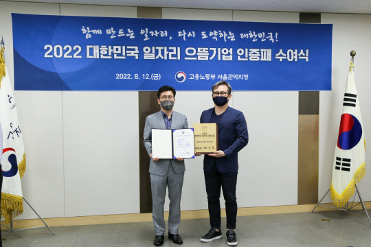 이하영(오른쪽) 넷마블에프앤씨 경영전략본부장과 윤옥균 고용노동부 서울관악지청장이 지난 12일 열린 2022 대한민국 일자리 으뜸기업 시상식에서 기념사진을 찍고 있다. 넷마블 제공