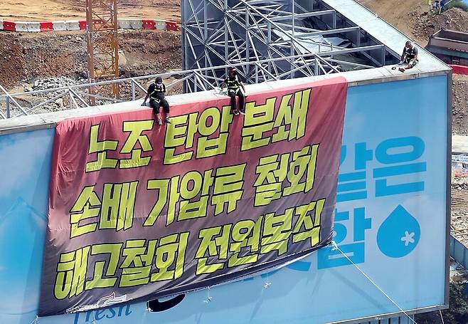 운송료 현실화 등을 요구하며 지난 6월2일부터 파업을 벌이고 있는 공공운수노조 화물연대본부 하이트진로지부 노조원들이 16일 서울 강남구 청담동 하이트진로 본사 사옥 옥상 광고판과 1층 로비를 점거하고 농성을 벌이고 있다. 강창광 선임기자 chang@hani.co.kr