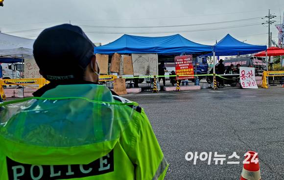 경기도 이천시에 위치한 하이트진로 이천공장 앞에서 도로 하나를 두고 수양물류 노조원들과 경찰이 대치하고 있다. [사진=김태헌 기자]