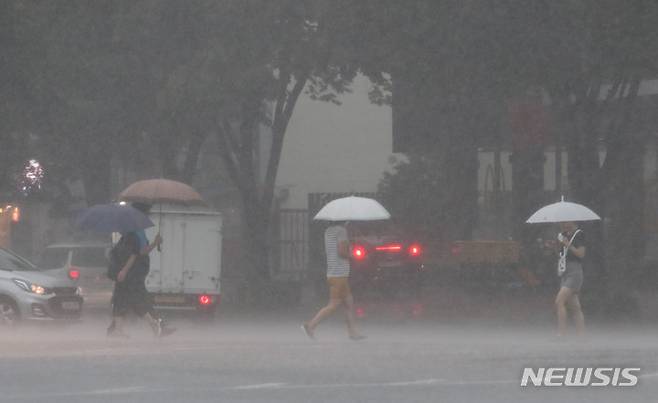 [서울=뉴시스] 권창회 기자 = 비가 내리고 있는 8일 오후 서울 강동구 둔촌역 인근에서 시민들이 우산을 쓰고 이동하고 있다. 2022.08.08. kch0523@newsis.com
