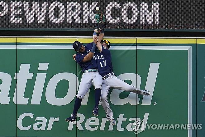 수비수 글러브에서 빠져나와 담장 위로 넘어가는 공 시애틀 매리너스의 중견수 훌리오 로드리게스와 우익수 미치 해니거가 16일(한국시간) 미국 캘리포니아주 애너하임 에인절스타디움에서 열린 로스앤젤레스 에인절스와 원정 경기 1-0으로 앞선 1회말 상대 팀 루이스 렌히포의 타구를 처리하기 위해 뛰어오르고 있다. 타구는 로드리게스의 글러브에 들어갔다가 빠져나와 펜스를 넘어갔고, 심판진은 홈런을 선언했다. [AP=연합뉴스]