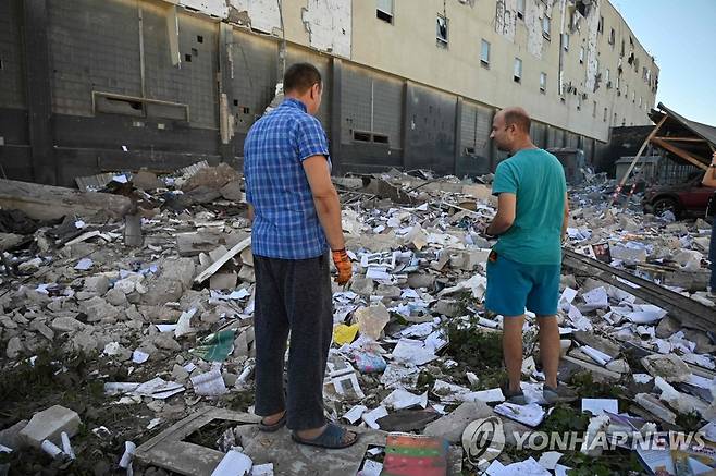 러군 미사일 공격으로 파괴된 하르키우 상가 (하르키우 AFP=연합뉴스) 지난달 31일(현지시간) 우크라이나 제2의 도시 하르키우의 한 상가 잔해를 지역 주민들이 바라보고 있다. 이날 오전 러시아군이 미사일 공격을 하며 상가가 파괴됐다. 2022.7.31 alo95@yna.co.kr