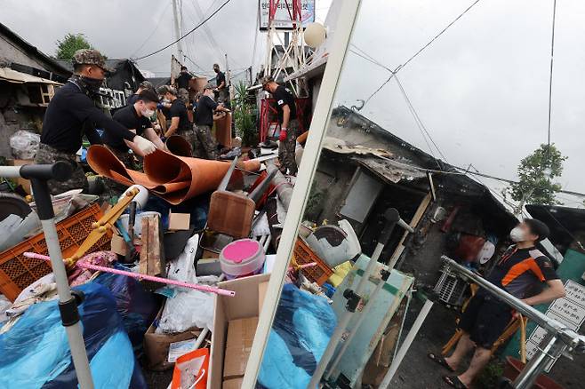 수해 복구 대민지원에 나선 육군 52사단과 56사단 장병들이 지난 11일 오전 대규모 수해를 입은 서울 송파구 화훼마을에서 비에 젖은 물건들을 정리하고 있다.(사진=연합뉴스)