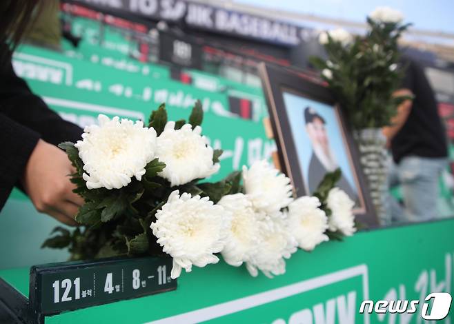 17일 부산 동래구 사직구장에서 고 캐리 마허 전 교수의 별세 소식을 들은 팬들이 캐리 마허가 자주 이용하던 좌석에 추모장소를 마련하고 있다. 2022.8.17/뉴스1 ⓒ News1 김영훈 기자