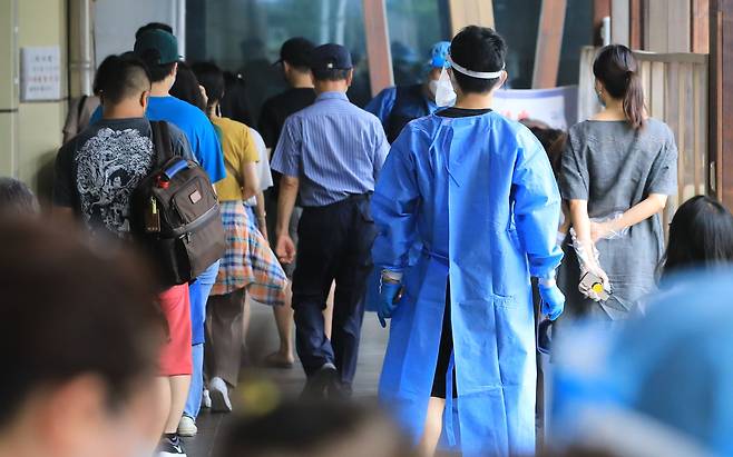 17일 오전 서울 송파구보건소에 마련된 신종 코로나바이러스 감염증(코로나19) 선별진료소에서 의료진이 검사를 위해 대기 중인 시민들을 안내하고 있다. 질병관리청 중앙방역대책본부는 이날 0시 기준 코로나19 신규 확진자가 18만803명 발생했다고 밝혔다. 2022.8.17/뉴스1