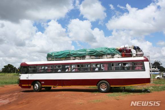 짐바브웨 하라레에서 학생들과 그들의 짐을 실은 스쿨버스가 출발하고 있다. 코로나19로 폐쇄됐던 짐바브웨의 학교들이 7일 재개교한다. [사진=하라레=AP/뉴시스]