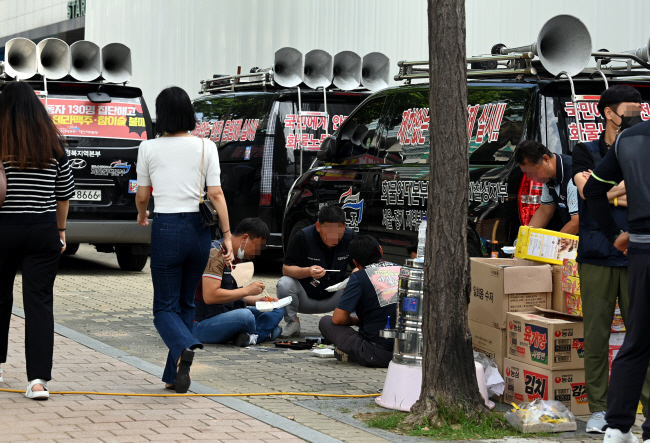 민주노총 공공운수노조 화물연대의 서울 강남구 하이트진로 본사 불법 점거 이틀째인 17일 오전 노조원들이 본사 앞 인도에서 아침 식사를 하고 있다.  윤성호 기자