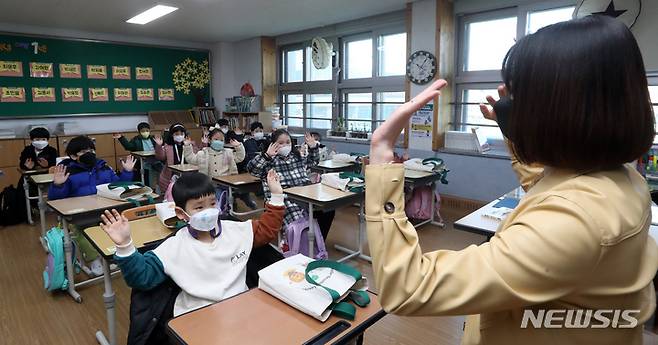 [전주=뉴시스] 김얼 기자 = 2022학년도 새 학기 개학날인 2일 전북 전주시 전주삼천초등학교에서 1학년 학생들이 선생님과 인사를 나누고 있다. (전북사진기자단 공동 취재 사진) 2022.03.02. pmkeul@nwsis.com