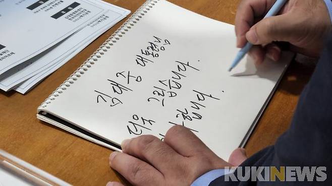 음악회 참석자들이 고 김대중 전 대통령을 그리워하면서 방명록에 글을 적고 있다.&nbsp; &nbsp;사진=황인성 기자