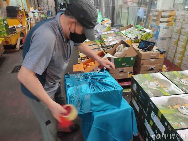 17일 오전 서울 송파구 가락동농수산물시장에서 한 과일 도매업자가 추석 선물세트를 포장하고 있다.  /사진=정세진 기자