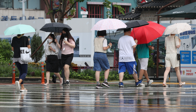 전국 대부분 지역에 소나기가 예보된 22일 오후 서울광장 인근에서 시민들이 우산을 쓴 채 이동하고 있다. 연합뉴스