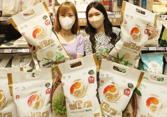 롯데마트 모델들이 서울역점에서 K-품종 ‘빠르미’ 쌀을 소개하고 있다.(사진=롯데마트)