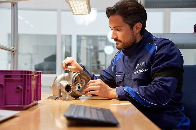 3D 프린터로 출력한 부품의 후처리를 완료하고 치수를 검사하는 모습, 출처: BMW