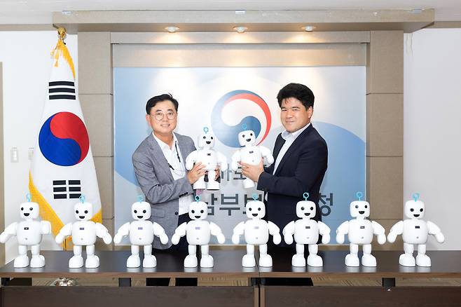 Choi Hyung-sik, left, executive in charge of communications at Hyosung Group, poses with Kang Byung-koo, right, head of Ministry of Patriots and Veterans Affairs’ Southern Seoul Regional Office, on Friday after delivering AI care robots for seniors. (Hyosung)