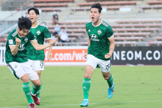 Jeonbuk Hyundai Motors' Song Min-kyu, right, celebrates after scoring a goal in the first half of a round of 16 AFC Champions League match against Daegu at Urawa Komaba Stadium in Japan on Thursday. [AFP/YONHAP]