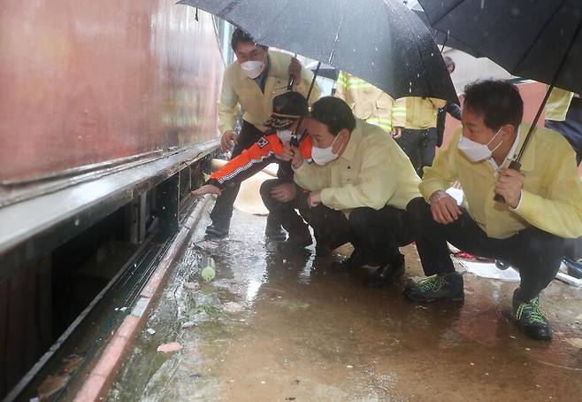 윤석열 대통령이 9일 서울 관악구 신림동 침수 피해 사망 사고 현장을 찾아 설명을 듣고 있다. 오른쪽은 오세훈 서울시장. 대통령실사진기자단