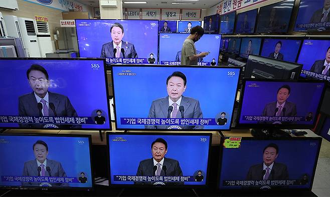 지난 17일 서울 용산구 용산전자랜드에서 시민들이 윤석열 대통령 취임 100일 기자회견을 TV 생중계를 통해 지켜보고 있다. 뉴스1