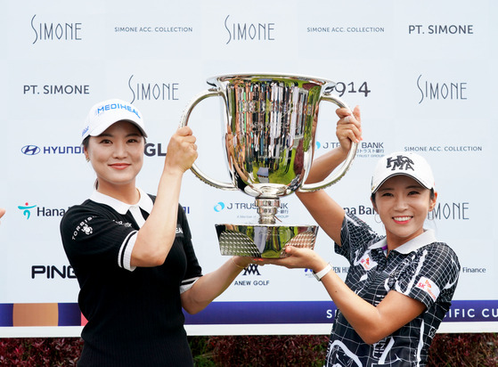 Ryu So-yeon, left, and Lee Bo-mee hold up the Simone Asia Pacific Cup team trophy at Pondok Indah golf course in Jakarta, Indonesia, on Saturday. [YONHAP]