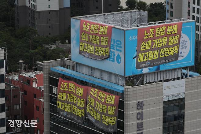 기약 없는 파업 민주노총 공공운수노조 화물연대 조합원들이 점거 농성 중인 서울 강남구 하이트진로 본사 옥상과 건물 외벽에 22일 노조의 주장이 적힌 대형 현수막들이 걸려 있다. 화물연대는 지난 16일 손해배상 소송 및 가압류 철회와 해고자 원직 복직 등을 요구하며 농성에 들어갔다. 성동훈 기자 zenism@kyunghyang.com