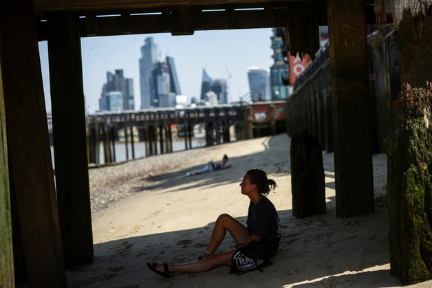 (런던 로이터=뉴스1) 유민주 기자 = 19일(현지시간) 영국 런던의 템스 강 근처 그늘에서 한 여성이 쉬고 있다.  (C) 로이터=뉴스1