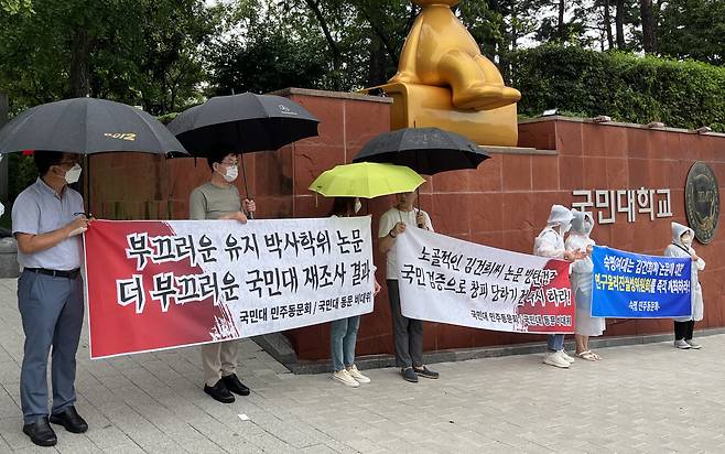 8일 국민대 정문 앞에서 국민대 동문 비상대책위원회가 윤석열 대통령 부인 김건희 여사가 2007년 쓴 박사학위 논문조사 결과에 항의하는 현수막을 들고 시위를 하고 있다. 김 여사의 석사학위 논문 표절 의혹을 살펴보고 있는 숙명여대의 민주동문회도 숙명여대에 연구윤리진실성위원회 개최를 촉구하는 현수막을 들고 동참하고 있다. [연합]
