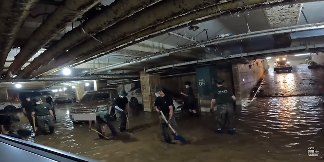 침수 피해 지역 대민 지원을 나온 군인들이 경기 성남시 판교의 한 오피스텔 지하 주차장에서 침수 현장을 복구하고 있는 모습. 자동차 리뷰 유튜버 모트라인 유튜브 캡처