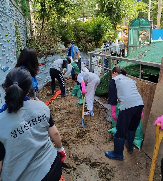 경기 성남산업진흥원 직원들이 최근 집중호우로 피해를 입은 상대원동 일대를 방문해 수해복구를 돕고 있다.