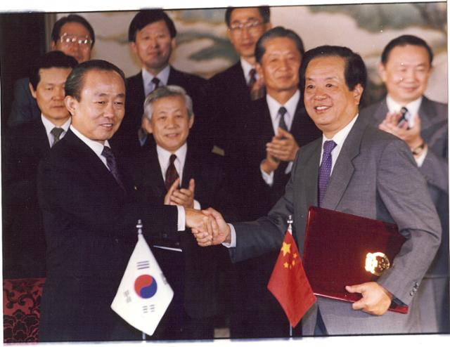 1992년 8월 24일 이상옥(왼쪽) 당시 외교부 장관과 첸치천 중국 외교부장이 중국 베이징 댜오위타이 국빈관에서 한중 수교 합의문에 서명한 뒤 악수하고 있다. 연합뉴스
