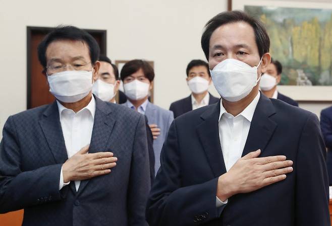 우상호(오른쪽) 더불어민주당 비상대책위원장과 변재일 중앙위원회 의장 등 참석자들이 24일 오전 국회에서 열린 제6차 중앙위원회에서 국민의례를 하고 있다.(사진=연합뉴스)