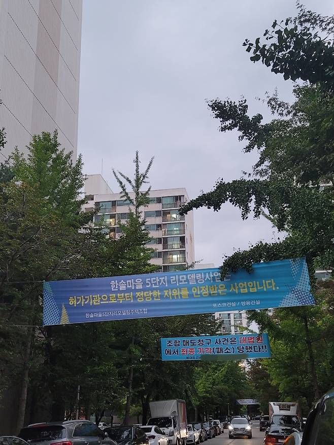 한솔마을5단지 내 리모델링조합과 비대위가 각각 내건 현수막이 붙어있다./채신화 기자