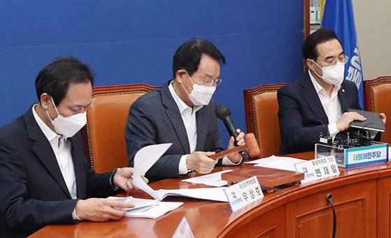 더불어민주당 변재일 중앙위원회 의장(가운데)이 24일 국회에서 열린 중앙위원회에서 당헌 개정안을 상정하고 있다. 이날 ‘당의 최고 대의기관인 전국대의원대회 의결보다 권리당원 전원투표를 우선한다’는 조항을 신설하는 내용의 당헌 개정안은 과반의 찬성을 얻지 못해 부결됐다. 김성룡 기자