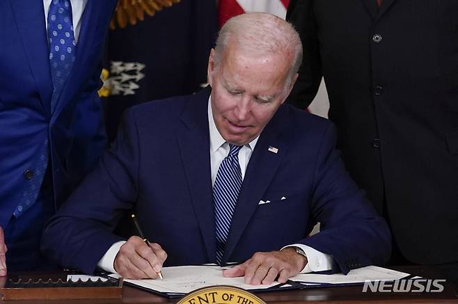 [워싱턴=AP/뉴시스] 조 바이든 미국 대통령이 16일(현지시간) 백악관 스테이트 다이닝룸에서 기후변화 대응과 의료보장 확충 등의 내용이 담긴 '인플레이션 감축법'에 서명하고 있다. 바이든 대통령은 이와 관련한 연설에서 "이 법은 내일에 관한 것"이라며 "미국 가정에 번영과 진보를 가져다주는 것"이라고 말했다. 2022.08.17.